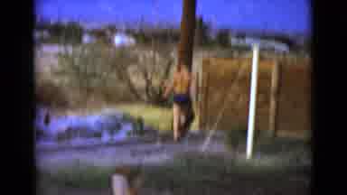CLARKSDALE ARIZONA-1968: Multiple Kids Playing Outside In The Mud By A Wooden